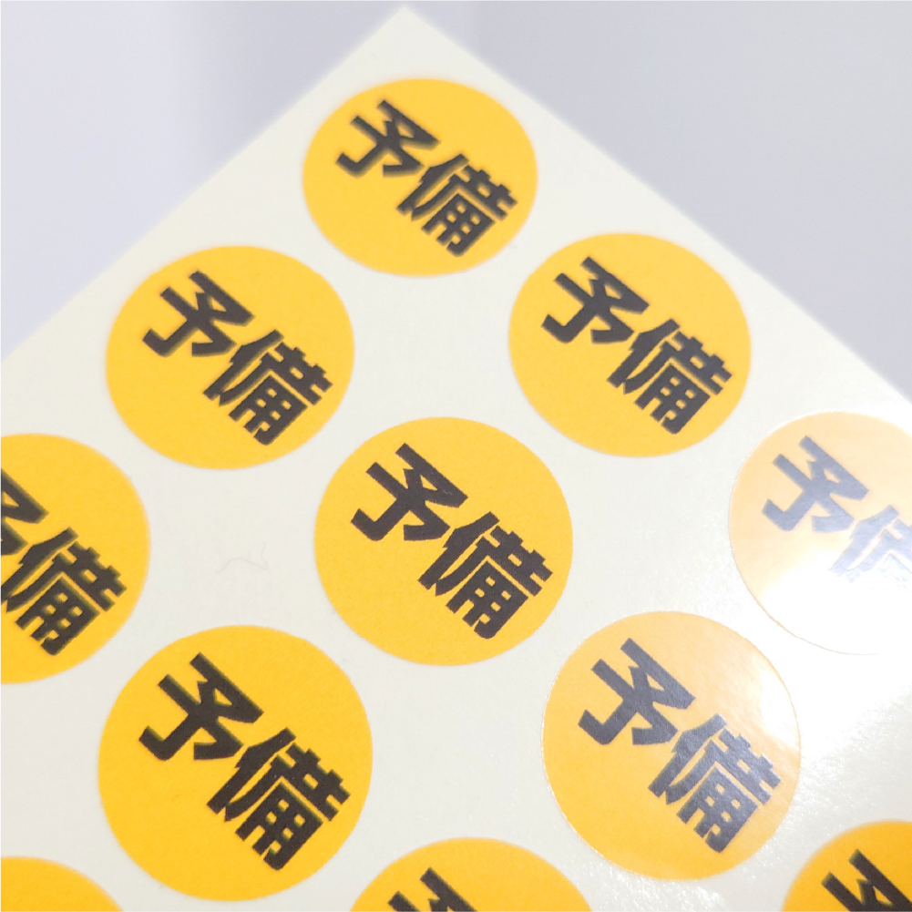 黄色地に黒文字で予備と表示された丸型シール